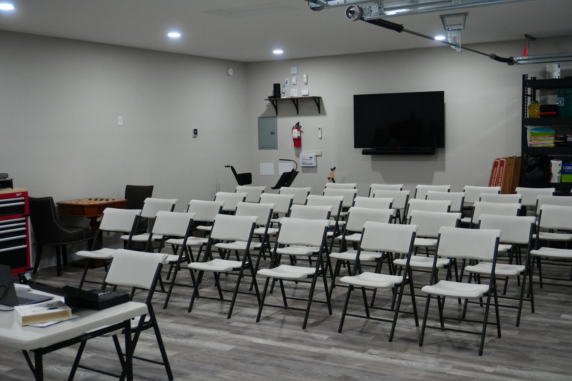 Folding chairs arranged classroom-style facing wall-mounted TV