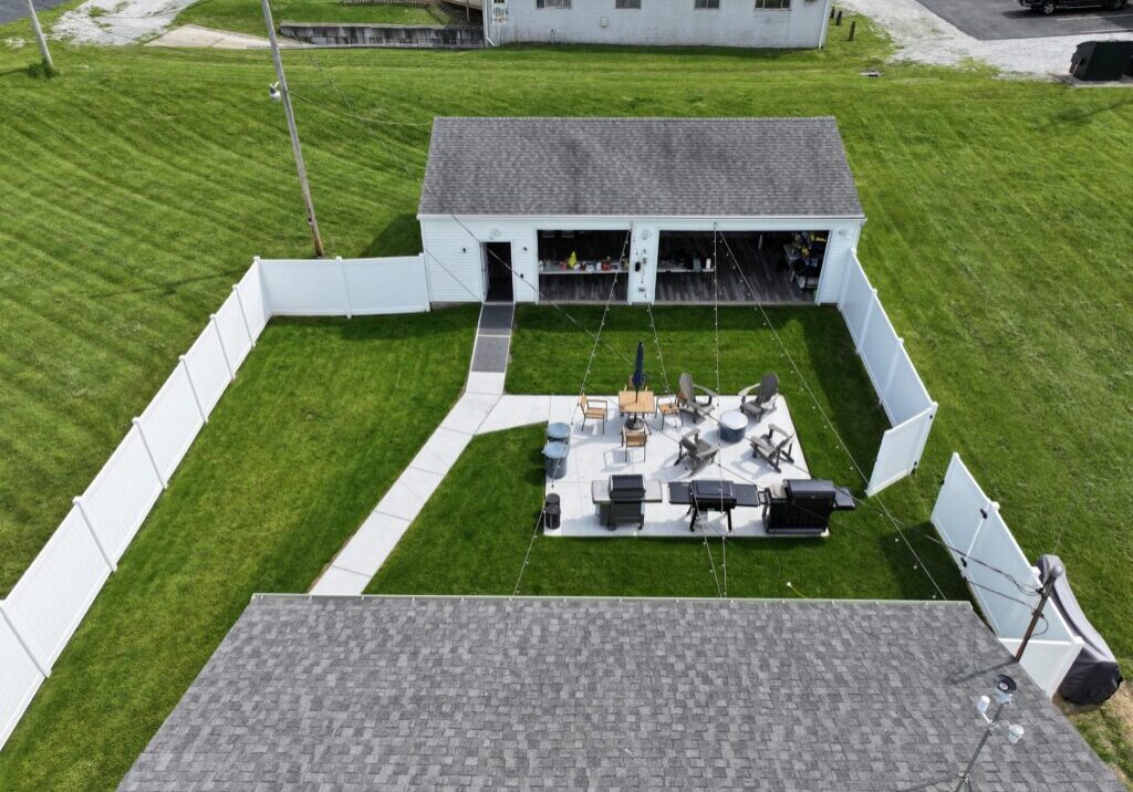 Aerial view of fenced backyard patio and shed